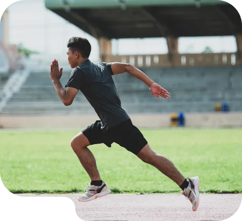 Jovem atleta a sprintar numa pista de estádio durante uma intensa sessão de treino ao ar livre.