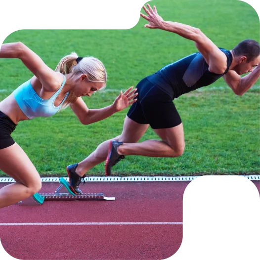 Corredores masculinos e femininos a arrancar dos blocos de partida numa pista de atletismo durante uma corrida de velocidade competitiva.